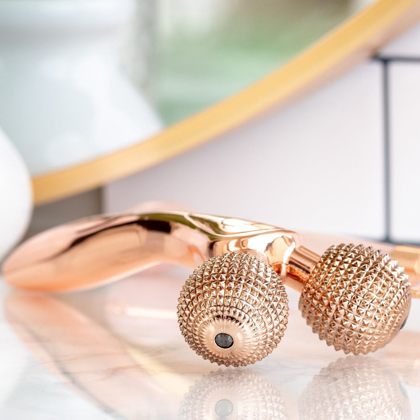 side ways views of rose gold epic skin tool displayed on counter