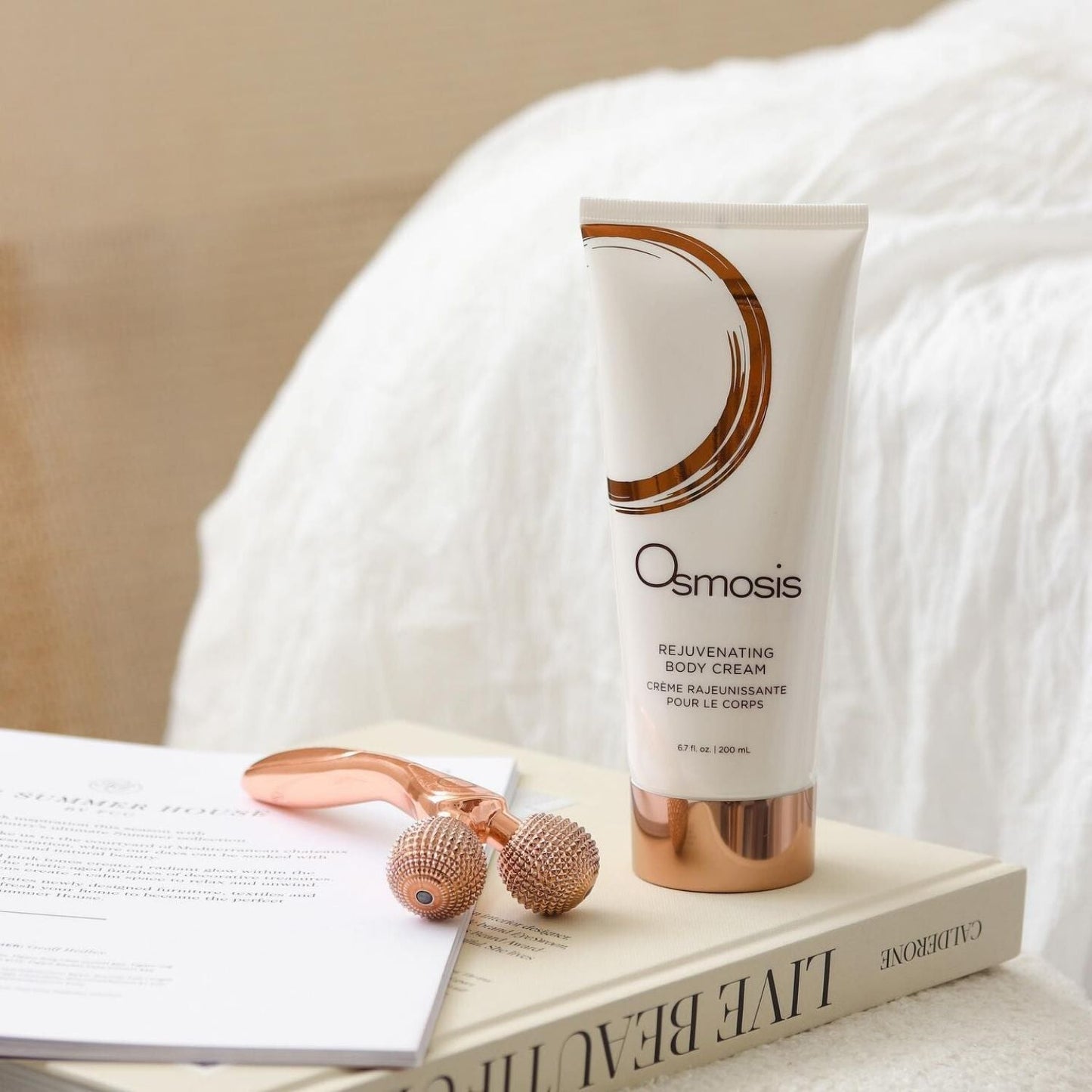 roller tool and cream in tube displayed on bedside table with books
